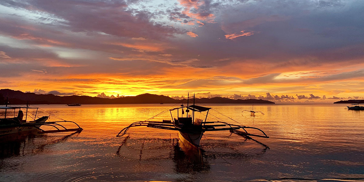 Bangka au coucher du soleil dans la baie de Port Barton